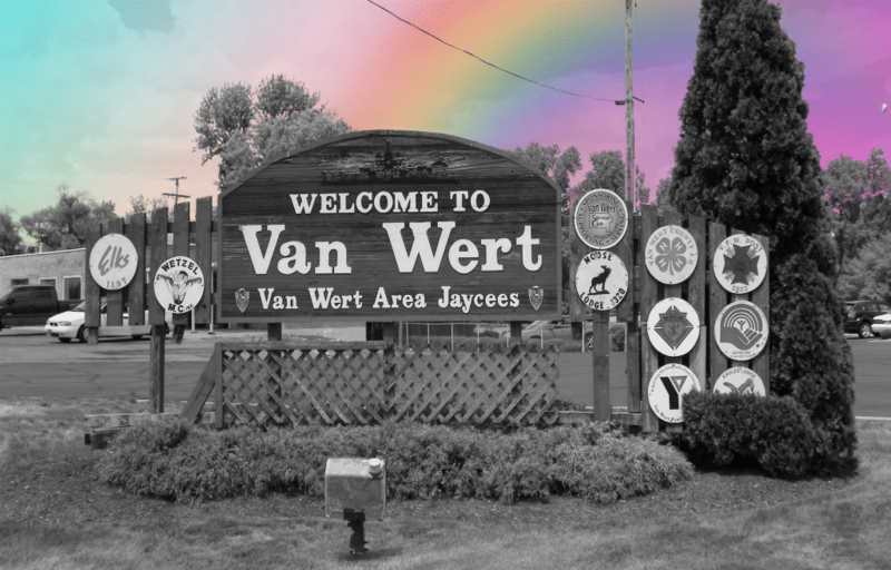 A photo of Van Wert’s town sign in black and white with a rainbow superimposed in the background as if it’s spilling into the image.